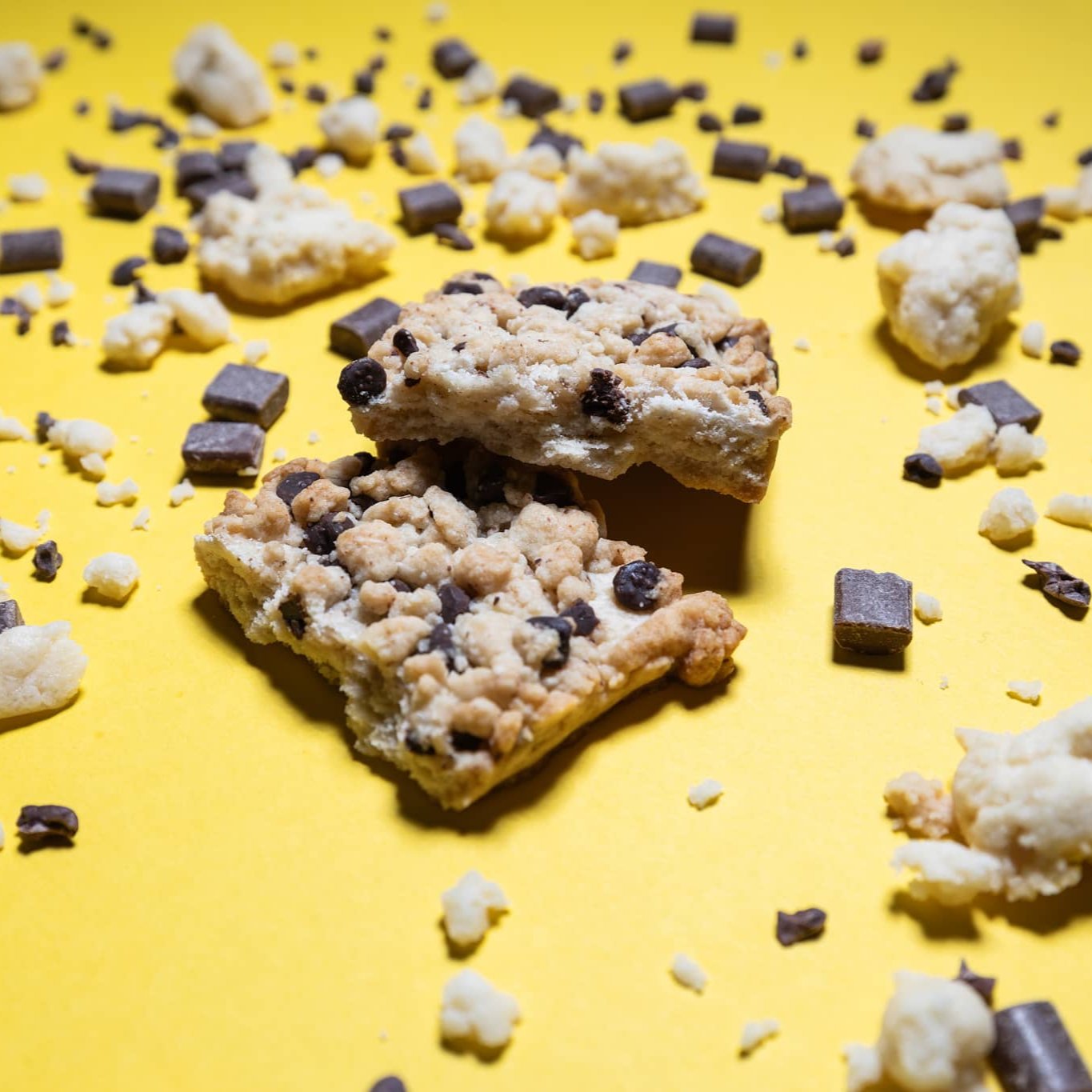 zerteiltes Streuselgebäck ist umgeben von Schokostücken und Streuselteig